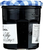 Imported French style black currant jam jar placed next to fresh breakfast pastries and berries