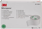 Twelve rolls of Micropore white paper adhesive medical tape arranged neatly outside the packaging carton.