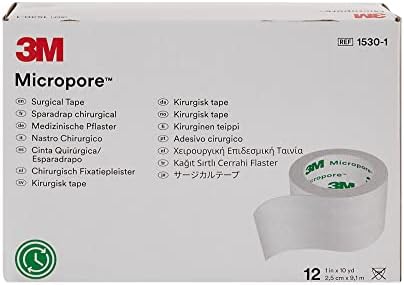 Twelve rolls of Micropore white paper adhesive medical tape arranged neatly outside the packaging carton.