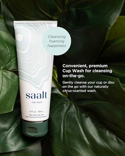 Person using Saalt squeeze bottle to rinse a menstrual disc in a travel setting.