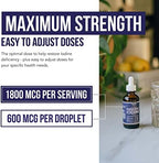 Clear liquid iodine drops being dispensed from a premium glass dropper bottle.