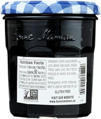 Authentic Bonne Maman blackcurrant conserve jar on a kitchen table showcasing ingredients and smooth purple texture