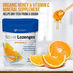 Individually wrapped orange flavored silver throat lozenges spread out on table