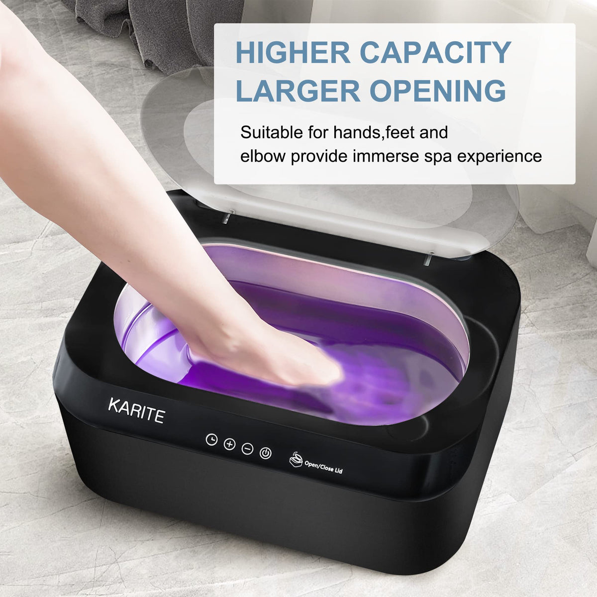 User safely dipping a hand into the warm liquid wax inside the Karite therapeutic machine.