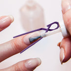 Close up of lavender plastic nail art shield applied on a fingertip for self doing manicures.