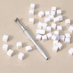Close up of metal four-claw grabbing pen holding a soft sponge