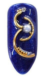 Close up of crescent shaped half moon nail art studs and gold rivets for intricate gel nail decorations.