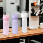 Three pack of YANTAISIYU reusable hair care bottles in pink white and purple colors