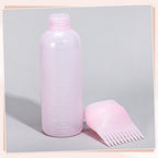 Flexible plastic body of the Pimoys scalp applicator bottle being gently squeezed to demonstrate liquid flow control.