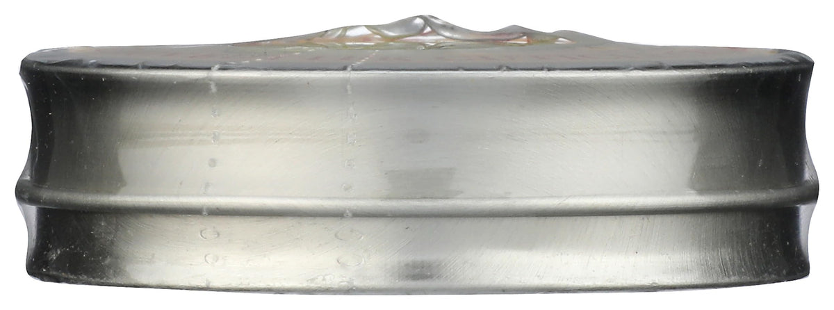 Close up shot of the lemon oil infused nail treatment tin placed next to fresh citrus ingredients for a clean beauty lifestyle view.