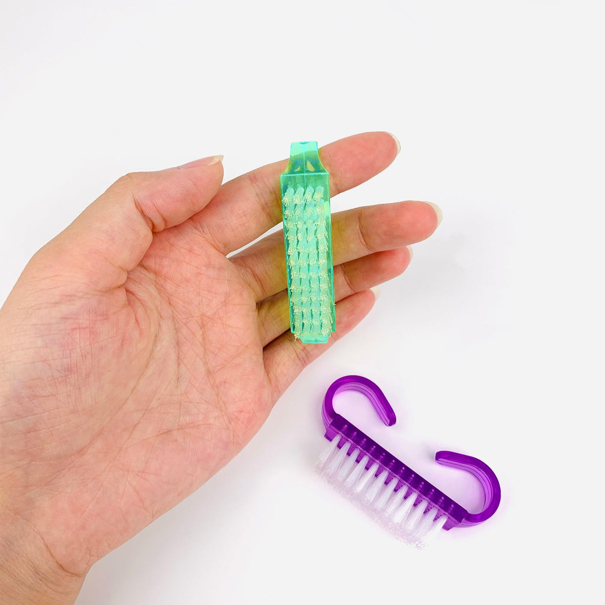 Sturdy plastic manicure dust remover brushes hanging from bathroom hooks