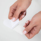 Demonstration of the EZ Strip peel off backing being removed from the water resistant pedicure pad.
