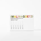 An overhead flat-lay of the authentic imported MALIN+GOETZ fragrance discovery kit showing all six signature scents.