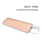 Hot pink silicone pouch storing a warm curling iron wand on a bathroom counter