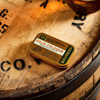 Duke Cannon cologne tin held in hand for scale