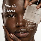 DIME Dans Les Bois 1.7 Ounce bottle on an elegant clean beauty setup.
