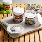 Detailed view of the eucalyptus spearmint and lemon basil aromatherapy salt textures inside the clear jars.
