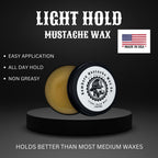 Open tin of Bombero Light Hold mustache wax showing texture