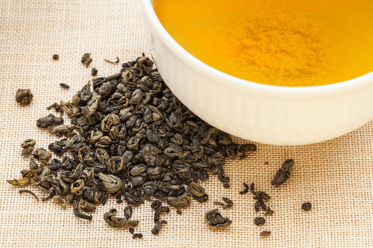 Top view of premium organic green tea leaves in a bowl