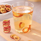 Pouring hot water over premium seedless hawthorn slices in a porcelain cup
