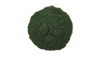 Pure dark green spirulina powder being scooped out for an antioxidant rich smoothie recipe.